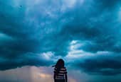 Woman standing in front a oncoming storm